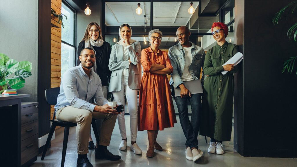 Successful business professionals smiling cheerfully in a modern office. Group of multicultural businesspeople running a creative startup in an inclusive workplace. |