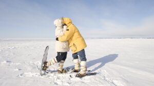 Two snowshoers kiss on the frozen snow on Great Slave Lake in Canada's Arctic. | Deux raquetteurs s'embrassent sur la neige gelée du Grand lac des Esclaves, dans l'Arctique canadien.