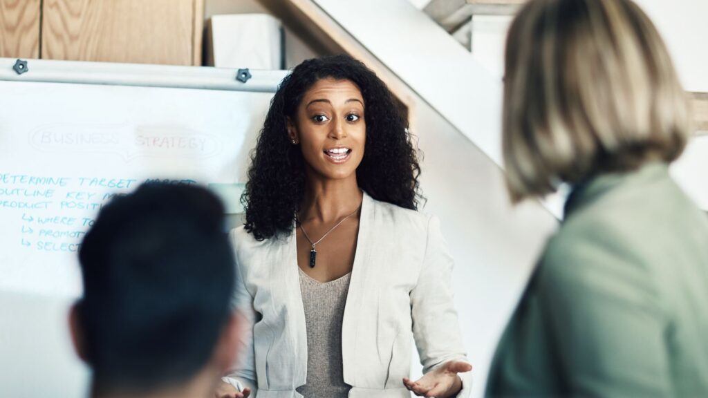 A woman engages in discussion with her colleagues during a meeting, showcasing collaboration and teamwork.