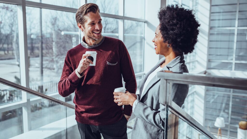 A man and woman engaged in conversation while standing on a stairwell, showcasing a moment of connection and dialogue.