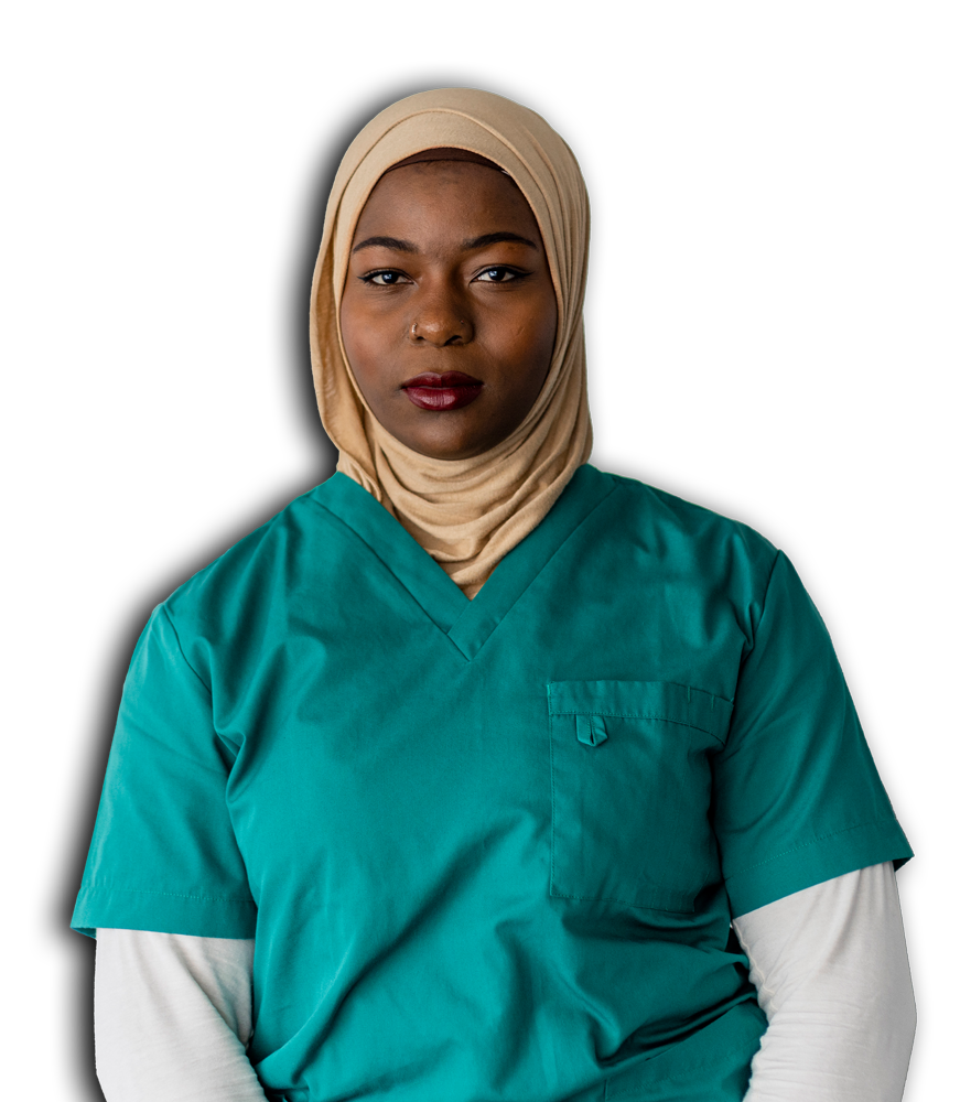 A woman in a green scrub suit is seated, appearing relaxed and focused in her environment.