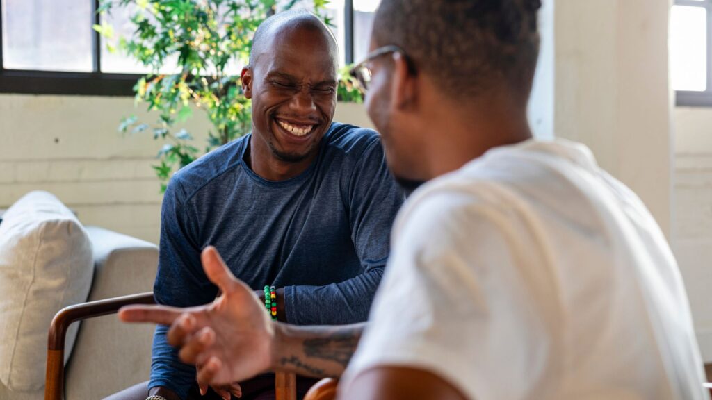 Two men engaged in conversation while seated in a cozy living room.