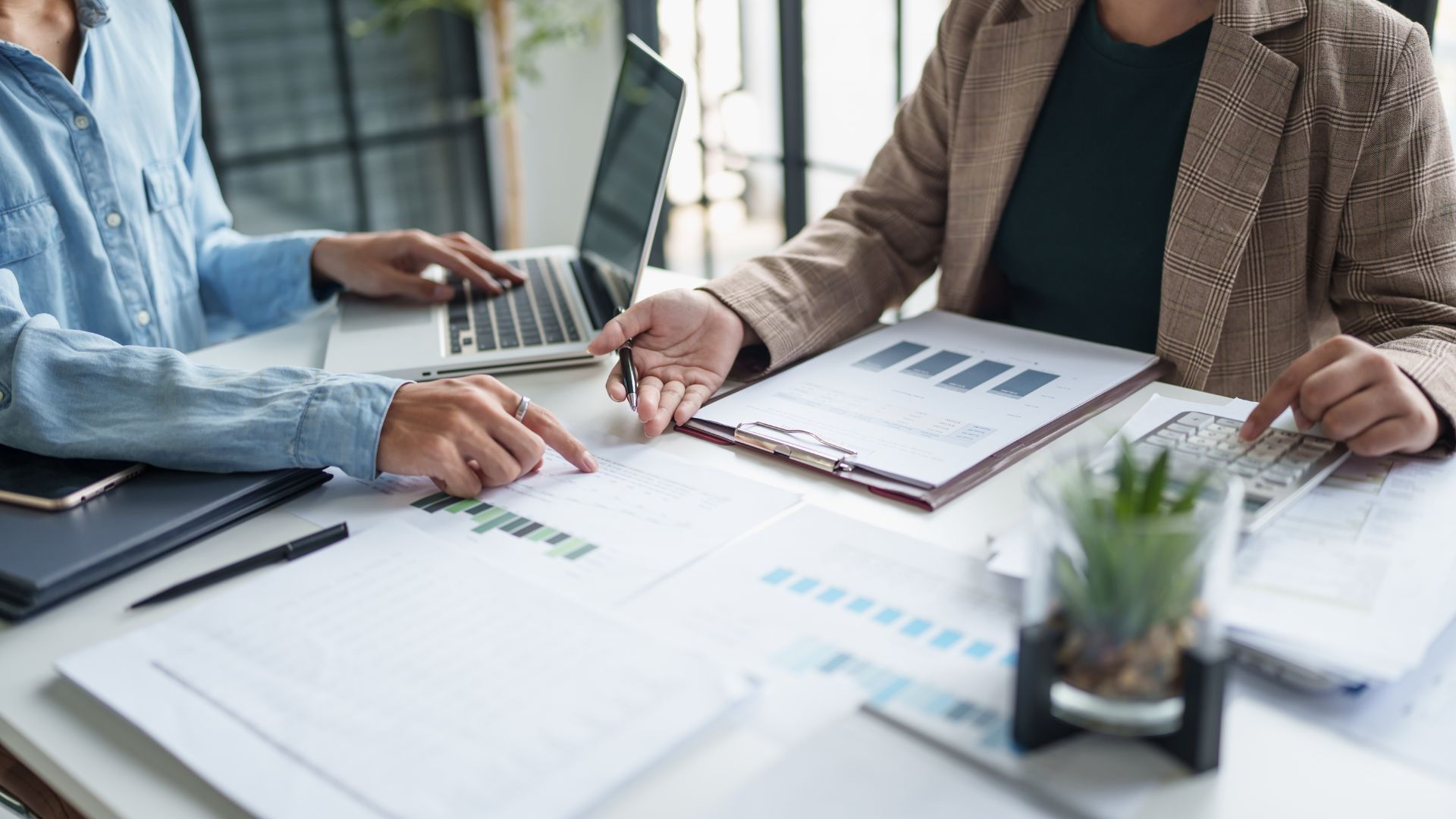 Business professionals collaborating on paperwork at a desk, focused on figuring ROI of mental health training