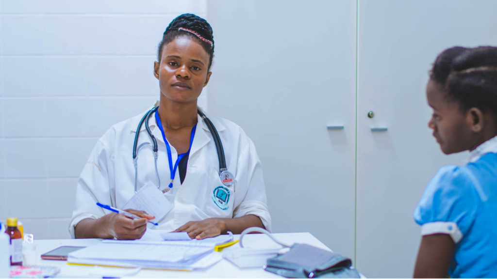 Physician sitting at a desk with a stethoscope during a patient consultation