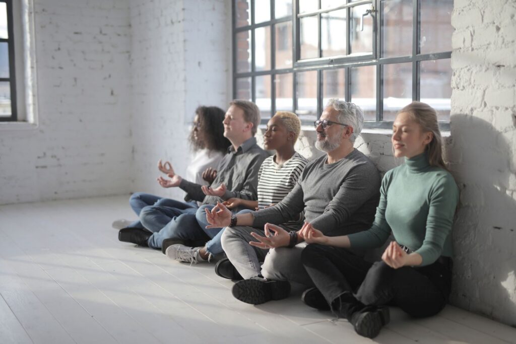 Group of coworkers taking a mindful break together in a bright office